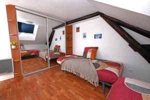 a room with two beds and a tv and mirrors at Ecrin calme à Nancy - A deux pas de la place Stanislas Appart 2ch in Nancy