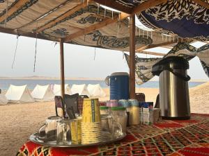 a table under a tent on the beach at Blend in Nature Eco Camp Beachfront Stay in Ras Mohamed, Sharm El Sheikh in Sharm El Sheikh