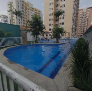 a large blue swimming pool with buildings in the background at Aconchegante apartamento Sinta-se em Casa in Belém