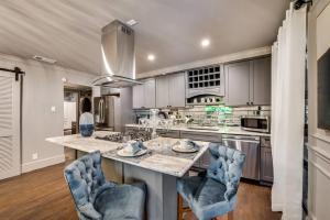 une cuisine avec une grande île dotée de chaises bleues dans l'établissement Peaceful Condo W Patio & Hot Tub Access, à Dallas