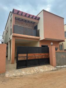 a house with a gate in front of it at Luxurious townhouse behind Achimota Mall in Accra +3 photos