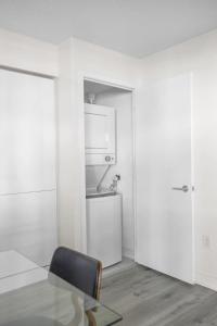 a white room with a glass table and a chair at Luxury Waterfront Escape Stylish 3BR Condo in Toronto +20 photos