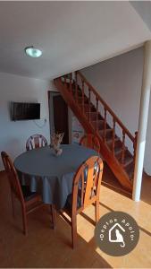 a dining room with a table and a staircase at Excelente Departamento en Calle 44 - Deptos Apolo in Las Toninas