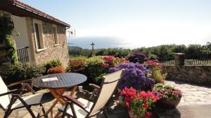 a patio with a table and chairs and flowers at Casa Golmar 20 in Cedeira