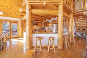 eine große Küche mit Holzbalken und Hockern in der Unterkunft Pegasus Luxe Mnt Retreat Stunning Views & Hot Tub in Big Bear Lake