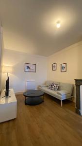 a living room with a couch and a table at Le Béarnois - 3 Chambres - Myra Conciergerie in Pau +2 photos