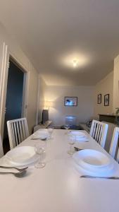a white table with plates and wine glasses on it at Le Béarnois - 3 Chambres - Myra Conciergerie in Pau