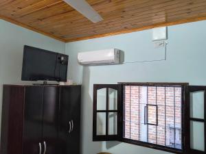 a living room with a tv and a window at Quincho en lo de Cacho in Goya