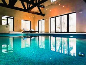 a large swimming pool in a building with windows at EXCL HOUSE in Warsaw with POOLS in Józefów
