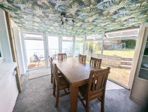 Un comedor con mesa y sillas de madera. en Central Pembrokeshire family home pets welcome 7 guests, en Neyland