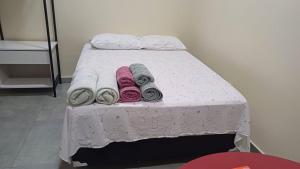 een bed met witte lakens en handdoeken erop bij Stúdio em ótima localização in Santarém