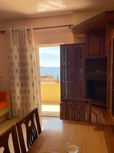 a dining room with a table and a large window at City Center Apartment Saranda in Sarandë
