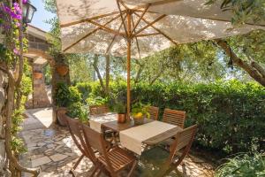 a wooden table with an umbrella on a patio at Villa Esposito in Massa Lubrense