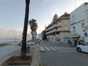 a city street with a palm tree and a building at ALCANAR DEL MAR in Les Cases d'Alcanar +3 photos