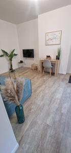 a living room with a vase with a plant in it at Urban Tribu Saumur Centre Parking facile 6 p in Saumur
