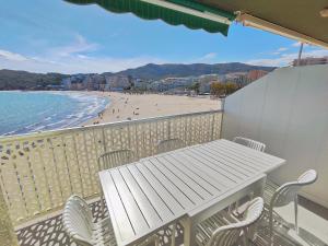 a balcony with a table and chairs and a beach at El mirador de La Concha in Oropesa del Mar