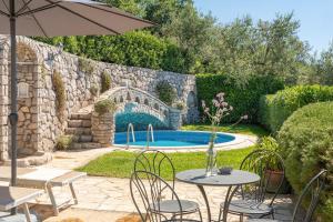 a patio with a table and chairs and a swimming pool at Villa Esposito in Massa Lubrense