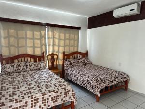 a bedroom with two beds and a window at Rincon el Mirador in Tamasopo