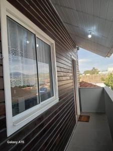 a balcony with a window on the side of a house at Vilamar in Florianópolis