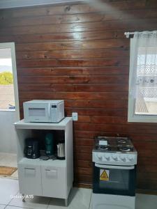 a small kitchen with a microwave and a stove at Vilamar in Florianópolis