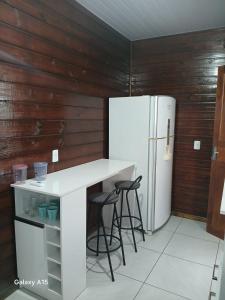 a kitchen with a white counter and a refrigerator at Vilamar in Florianópolis