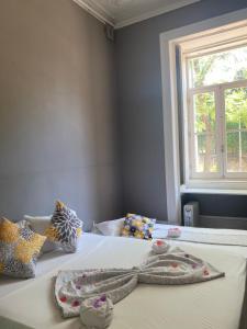 Un dormitorio con dos camas con almohadas y una ventana. en WW Hostel & Suites, en Coímbra