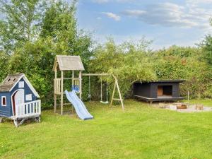 a playground with a slide and a play house at Spacious Retreat in Skovmose-By Traum in Neder Lysabild
