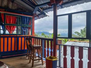 a wooden chair sitting on a balcony with a view at Casa La Aurora Posada in Restrepo
