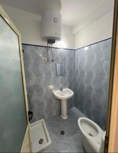 a bathroom with a sink and a toilet and a shower at Roku Apartment in Vlorë +9 photos