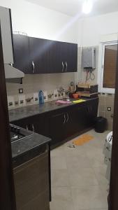 メクネスにあるReda Ghazalieのキッチン(黒いキャビネット、カウンタートップ付) +3枚の写真