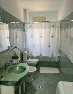 a bathroom with a sink and a toilet and a shower at Roku Apartment in Vlorë