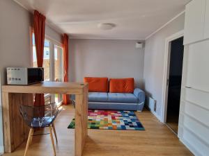 a living room with a blue couch and a table at Alpine Yard Nest Busteni in Buşteni