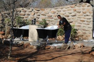 a man is standing next to a bath tub at Oase by 7 Star Lodges - Greater Kruger Private 530ha Reserve in Hoedspruit