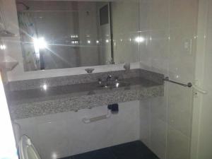 una persona tomando una foto de un lavabo del baño en El Cacique, en General San MartÃ­n