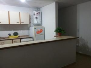 una cocina con encimera y refrigerador en El Cacique, en General San MartÃ­n