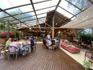 a group of people sitting at tables in a patio at Fazenda Boutique Vila dos Eucaliptos in Atibaia