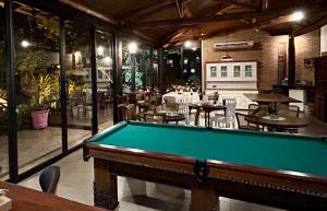 a pool table in a room with tables and chairs at Fazenda Boutique Vila dos Eucaliptos in Atibaia