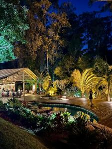 a garden at night with a pool and trees at Fazenda Boutique Vila dos Eucaliptos in Atibaia