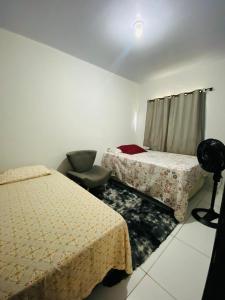 CastanhalにあるCasa para a COP 30のベッド2台と椅子が置かれた部屋