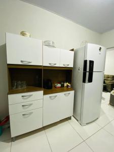 a kitchen with white cabinets and a refrigerator at Casa para a COP 30 in Castanhal