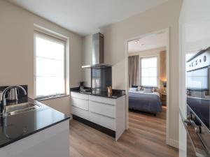 a kitchen with a sink and a room with a bed at SeaLuxe Residence in Colijnsplaat