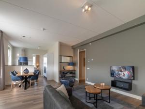 a living room with a couch and a table at SeaLuxe Residence in Colijnsplaat