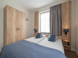 a bedroom with a large bed and a window at SeaLuxe Residence in Colijnsplaat