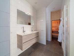 a white bathroom with a sink and a mirror at SeaLuxe Residence in Colijnsplaat +22 photos