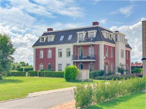 a large red and white house with a yard at SeaLuxe Residence in Colijnsplaat