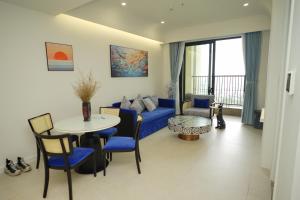 a living room with a blue couch and a table at 1BR Apt in Sunset Town Free Pool, Gym in Phu Quoc