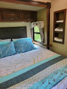 a bed with blue pillows and a mirror in a room at Aberdeen Hillview Retreat in Whycocomagh