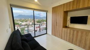 a living room with a couch and a large window at Modern, with Ocean and Mountain View in Puerto Vallarta