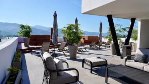 a patio with chairs and umbrellas on a roof at Modern, with Ocean and Mountain View in Puerto Vallarta