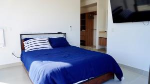 a bedroom with a bed with a blue comforter at Modern, with Ocean and Mountain View in Puerto Vallarta +30 photos